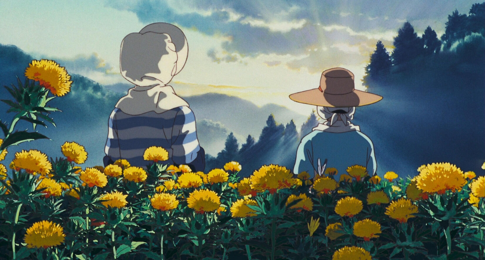 A screencap where Taeko and Kiyoko stand with their backs towards the viewer, watching the sun rise in the distance. At the foreground is a group of safflowers.